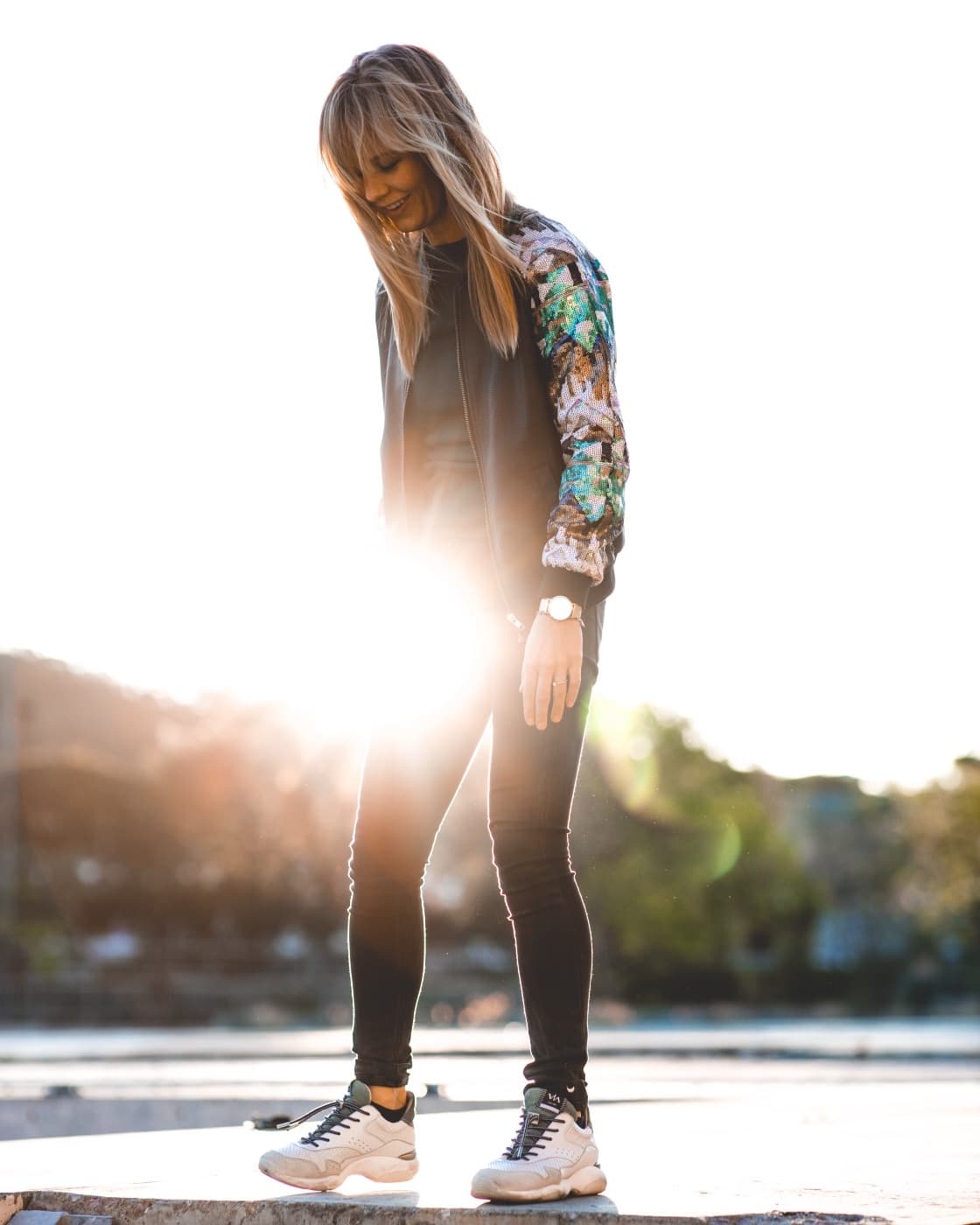 Denise standing outdoors with low sunlight coming in behind her